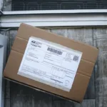 Paket kardus dengan label pengiriman siap diantar di depan pintu rumah